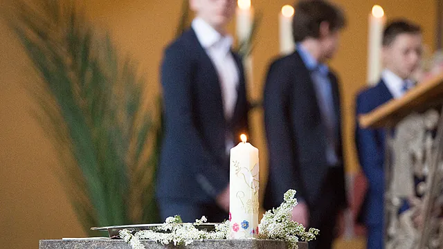 Konfirmanten stehen hinter den Altar